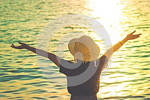 Women wearing a hat are enjoying a beautiful sunset on the beach