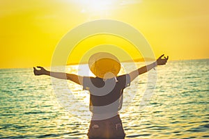 Women wearing a hat are enjoying a beautiful sunset on the beach