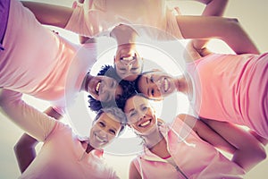 Women wearing pink for breast cancer with arms around