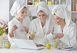 Women wearing a white bathrobes with laptop