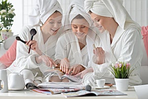 Women wearing a white bathrobes with magazine