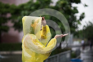 Women wearing yellow raincoat while raining in rainy season