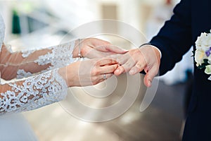 A women wears a wedding ring on the finger of a man on wedding ceremony