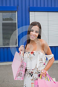 Women in white dress with shopping bags. Happy smile after buying presents. Pleasure of purchase.