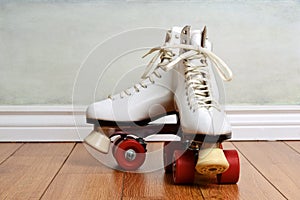 Women white quad roller skates on wood floor photo