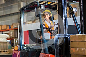 Women worker at forklift driver happy working in industry factory logistic ship. Woman forklift driver in warehouse area.
