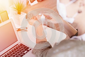 Women working from home she leaning her hands with sanitizer gel