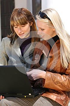 Women working with laptop in city park