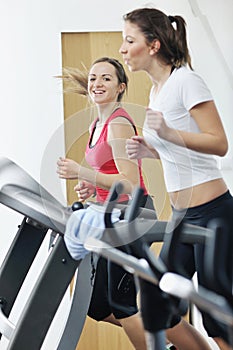 Women workout in fitness club on running track
