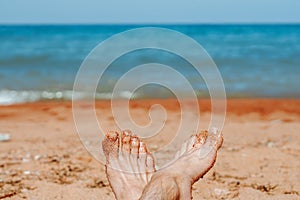 women's feet on the beach by the sea