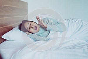 Woman yawning on her bedroom and tired sleepy,Symptoms and sleepiness photo