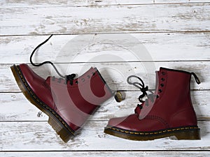 Womens accessories, footwear burgundy boots, yellow wireless headphones. Fashion outfit, shopping concept, flat lay