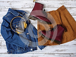 Womens clothing, accessories, footwear burgundy boots, yellow wireless headphones, denim jacket, suede skirt. Fashion outfit.