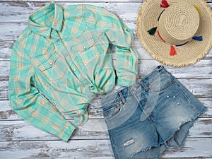 Womens clothing, accessories plaid shirt, denim shorts, straw hat. Fashion outfit, spring summer collection. Shopping concept.