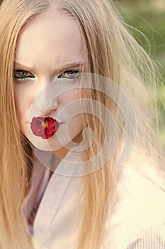 Womens day, 8 march, spring concept. Woman with red flower in mouth, 8 march. Fashion model with long blond hair