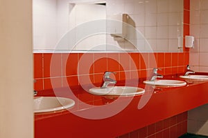 womens dressing room with red tiles on the wall, mirrors sinks for guests, toilet in the shopping center