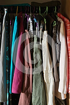 Womens everyday garments hanging in open wardrobe