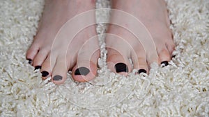 Womens feet are on beige carpet
