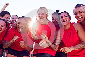 Womens Football Team Celebrating Winning Soccer Match On Outdoor Astro Turf Pitch