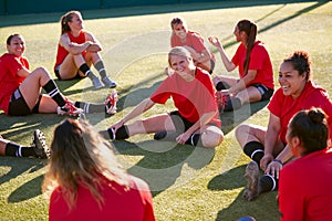 Womens Football Team Stretching Whilst Training For Soccer Match On Outdoor Astro Turf Pitch photo