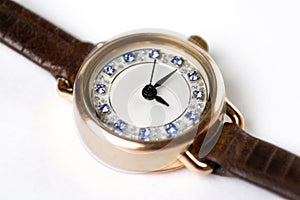 Womens gold watches on a leather strap. Close-up shot. On a whit