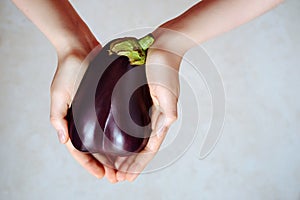 Womens hands hold an eggplant. Agriculture and agronomy. Close-up