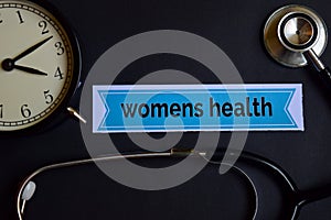 Womens Health on the print paper with Healthcare Concept Inspiration. alarm clock, Black stethoscope.