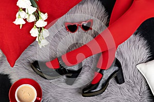 Womens legs in fashionable shoes on gray furry background