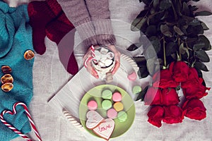 Winter breakfast in bed with red roses and heart of striped lollipop