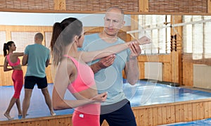 Womens self-defense workout with personal trainer, fighting training in gym