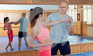 Womens self-defense workout with personal trainer, fighting training in gym