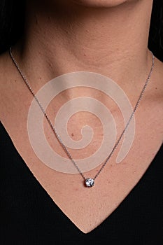 Womens silver chain with a pendant  with a stone hanging around his neck.