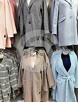 Womenâ€™s outerwear on display in store. Classic female coats in shop. Shopping