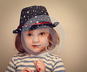 Wonder kid girl in trendy hat looking. Closeup vintage