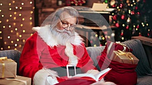 Wonder Santa Claus reading wishes book with astonished face expression. Medium shot on RED camera