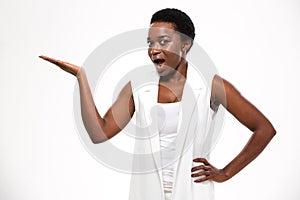 Wondered excited african woman standing and holding copyspce on palm