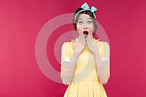 Wondered pinup girl in yellow dress with mouth opened