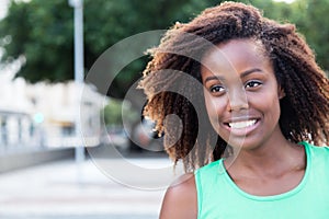 Wonderful african american woman in a green shirt outdoor