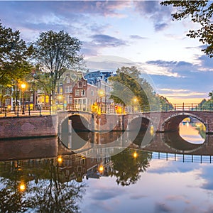 Wonderful Amsterdam.  Famous view of Amsterdam at dawn. Downtownr. The lanterns are still on, but the sun has already colored the