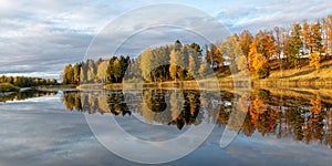 Wonderful autumn landscape with gorgeous and colorful trees by the water, beautiful reflections