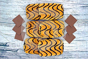 Wonderful biscuit cakes poured with chocolate stand on background