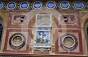 Wonderful element, of a richly decorated wall with a colored coat of arms in the center, at Villa Stibbert in Florence.