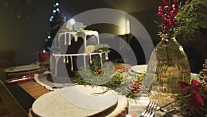 Wonderful festive cozy Christmas tree atmosphere in dining room with ginger cake on New Year celebration dinner table