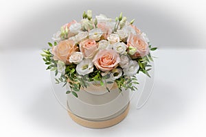 Wonderful flower arrangement in a hat box on a light background