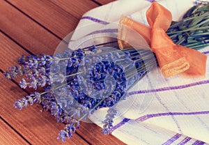 A wonderful fragrant bouquet of lavender with a bow on a wooden table.