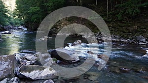 Wonderful fresh river water with rapids on flowing in mountain forest
