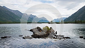 Wonderful lake wide panorama. Scenic summer landscape, mountains and blue cloudy sky at background. Eastern Sayan