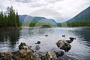 Wonderful lake wide panorama. Scenic summer landscape, mountains and blue cloudy sky at background. Eastern Sayan