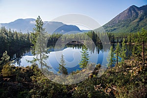 Wonderful lake wide panorama. Scenic summer landscape, mountains and blue cloudy sky at background. Eastern Sayan