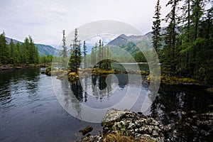 Wonderful lake wide panorama. Scenic summer landscape, mountains and blue cloudy sky at background. Eastern Sayan